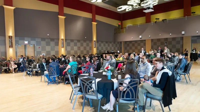people sitting at tables in the Performance Hall for a reception