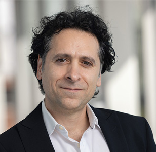 Zak Kassas in a black blazer and button down shirt