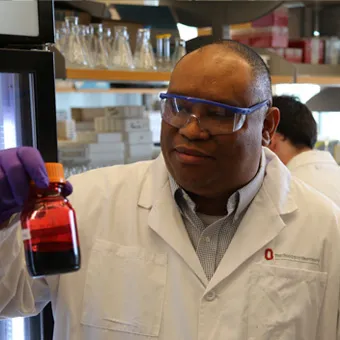 man looking at tube in lab