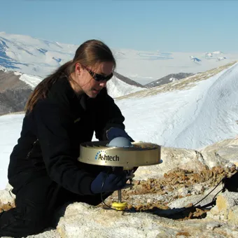 girl on glacier installing research equipment