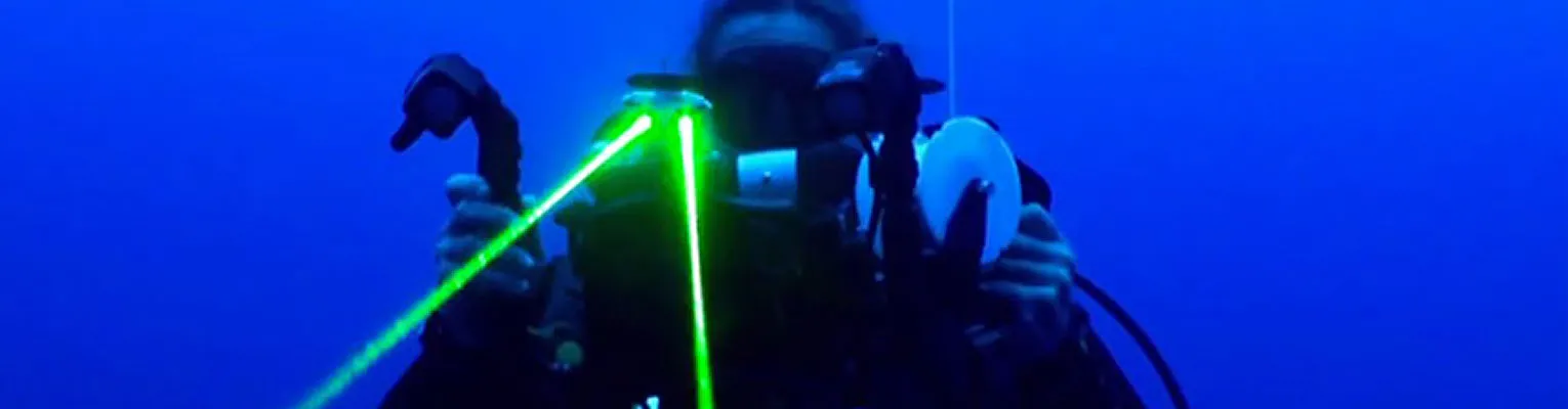 diver underwater with laser instrument