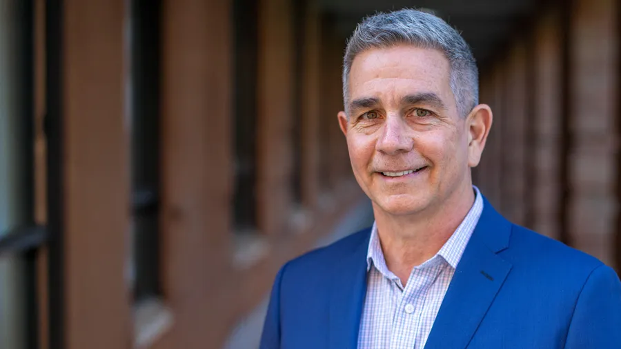 Scott Griffin in blue blazer outside by brick building