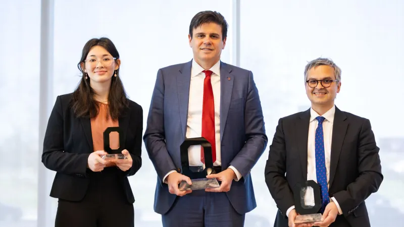 three people stand with their awards