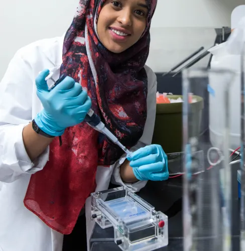 Female researcher using a pipette