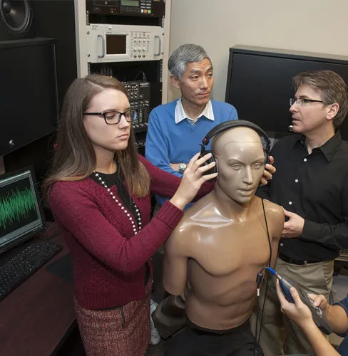 people and mannequin with headphones in speech and hearing lab