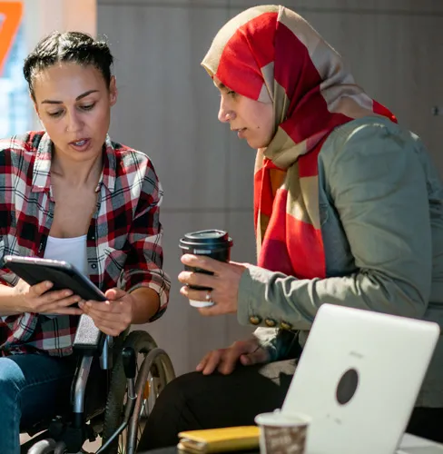 two women looking at a tablet