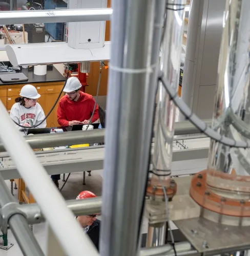 two researchers in hard hats in a lab