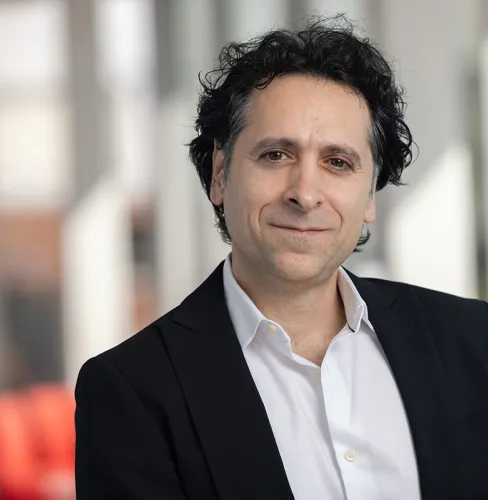 Zak Kassas in a black blazer and button down shirt