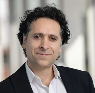 Zak Kassas in a black blazer and button down shirt