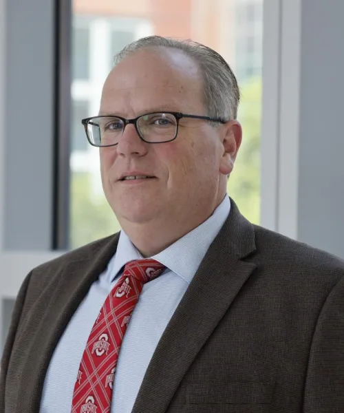 Loren Wold in a gray suit with red tie